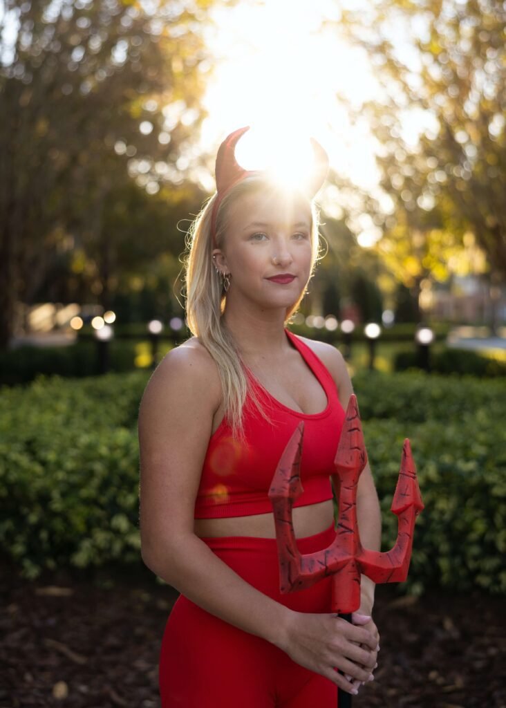 A woman is dressed up as the female Halloween character red devil.