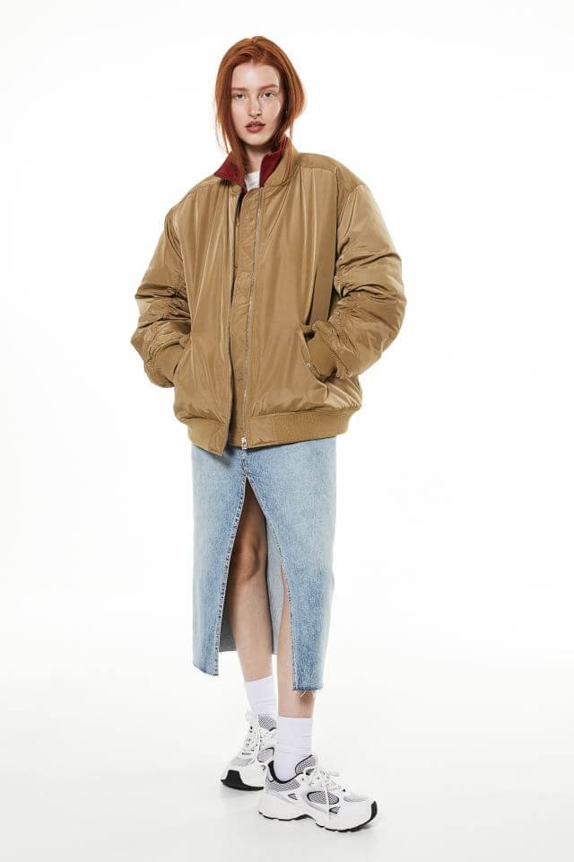 Autumns coats, a woman wears a brown oversized bomber jacket.