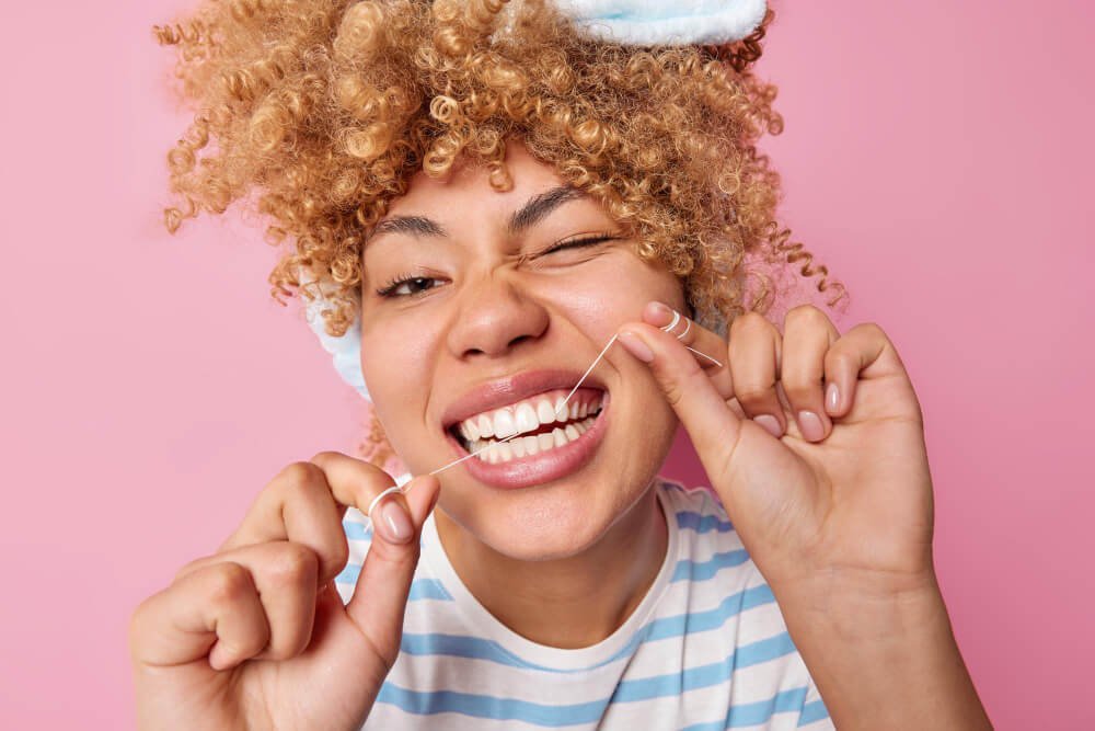 A woman flosses her teeth
