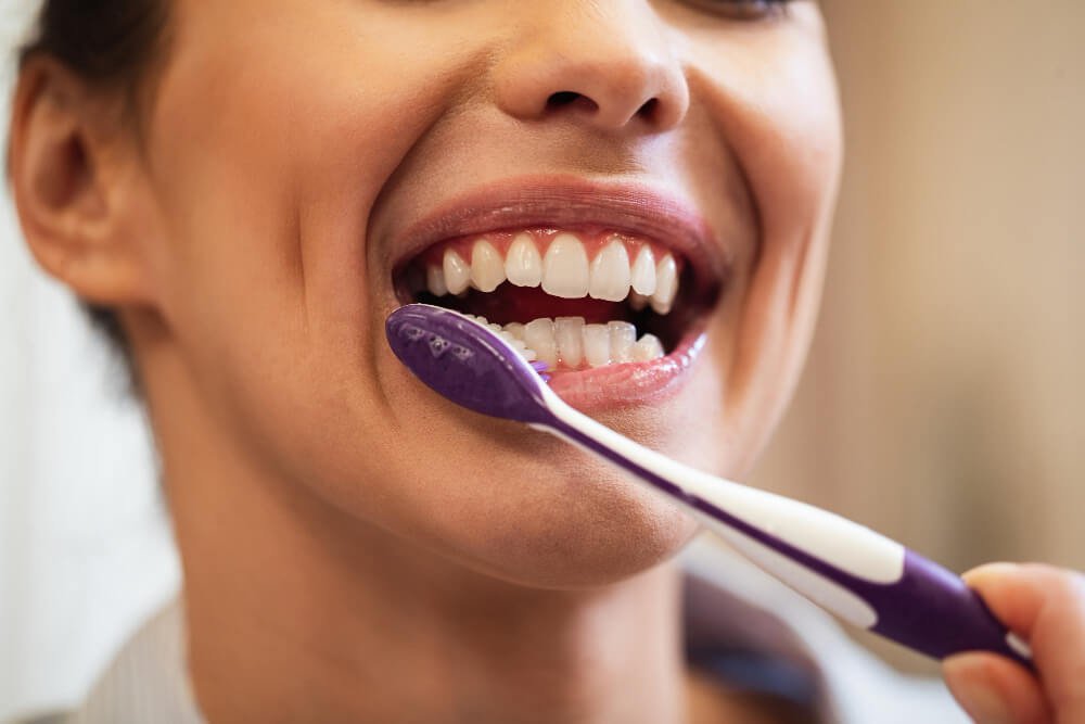 A woman brushes her teeth