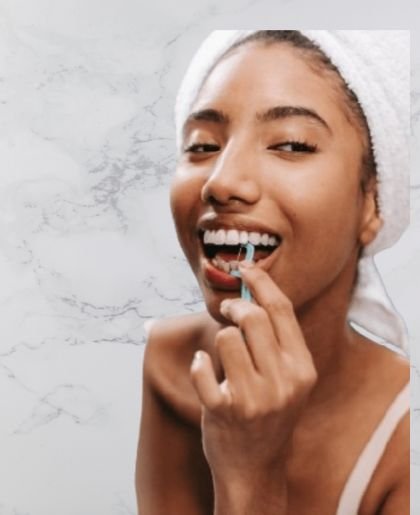 A woman flosses her teeth