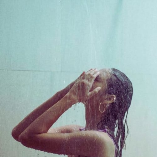 A woman washes her hair in the shower: Are cold showers good for your hair