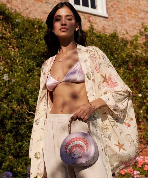 A woman wears a bikini and a Boho kimono