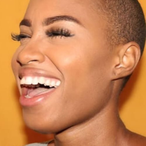 A woman with very white teeth is smiling