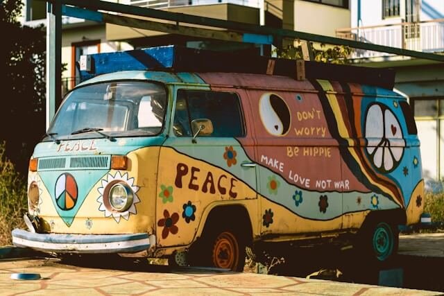 A VW van decorated with hippie slogans and colours