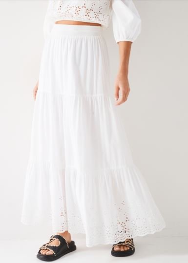 A model wears a white Boho style maxi-skirt with a white top.