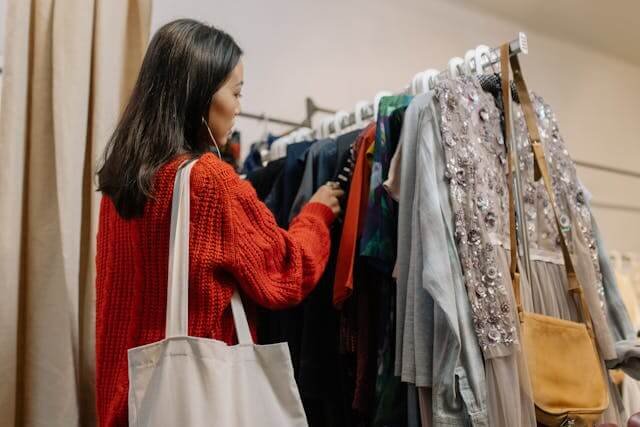A woman browses a clothes rail to choose what to wear on holiday in the evening.