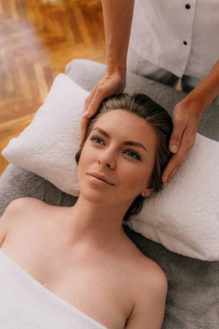 A woman is getting facial acupuncture