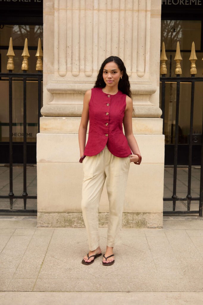 5 Easy Casual Dinner Outfits To Get Ready In Minutes
A woman with long brown hair wear a red button down waistcoat, beige trousers and black flip flop sandals.