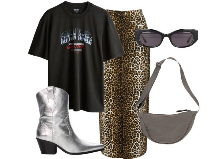 9 leopard skirt outfit ideas: Flat lay including a midi leopard print skirt, a black graphic t-shirt, black sunglasses, silver cowboy boots and a grey cross-body bag. 