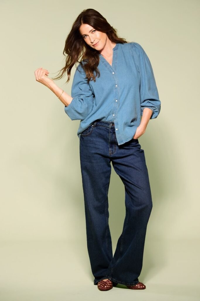 How to style wide leg jeans in Winter.
A brunette model wears indigo blue wide-leg jeans and a lighter denim shirt.